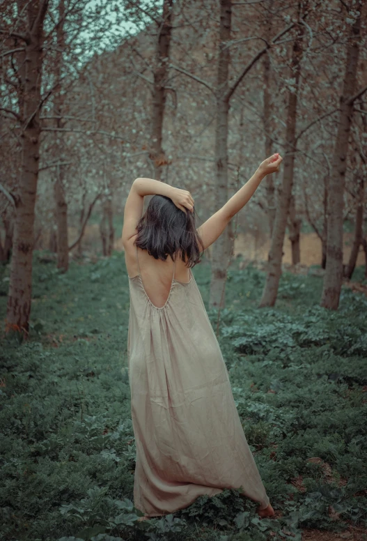 a person standing in the grass near trees