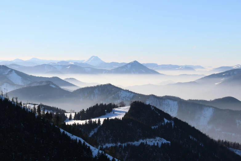 the mountains are covered with mist and trees