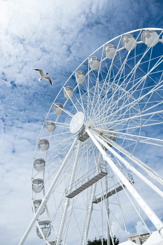 a large white ferris wheel sitting under a blue sky