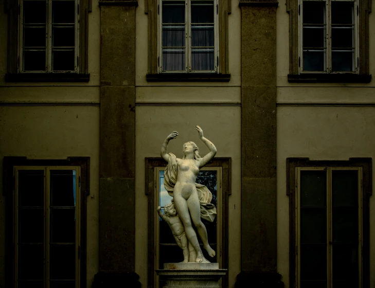 there is a statue of a man and a woman on the front of the building