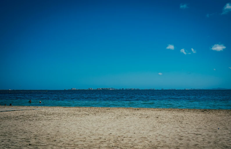 people are playing with a kite on a sandy beach