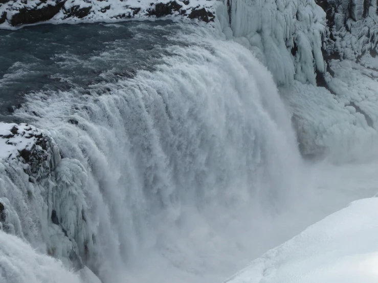 two skiers are skiing down the waterfall