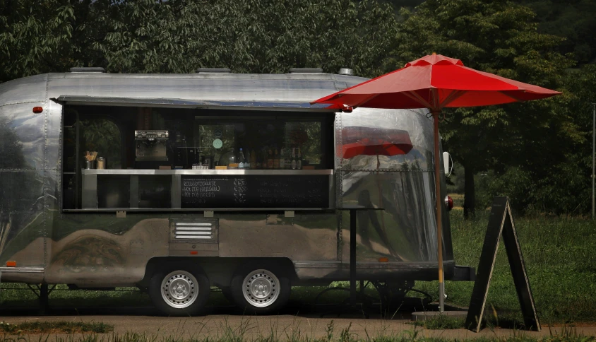 a food truck trailer with an awning and dining area