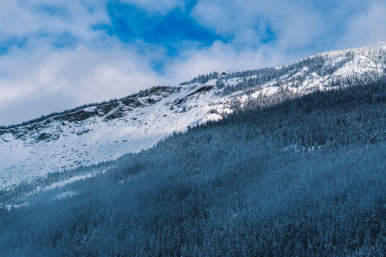 snow is covering the mountains as a skier rides a snowy path