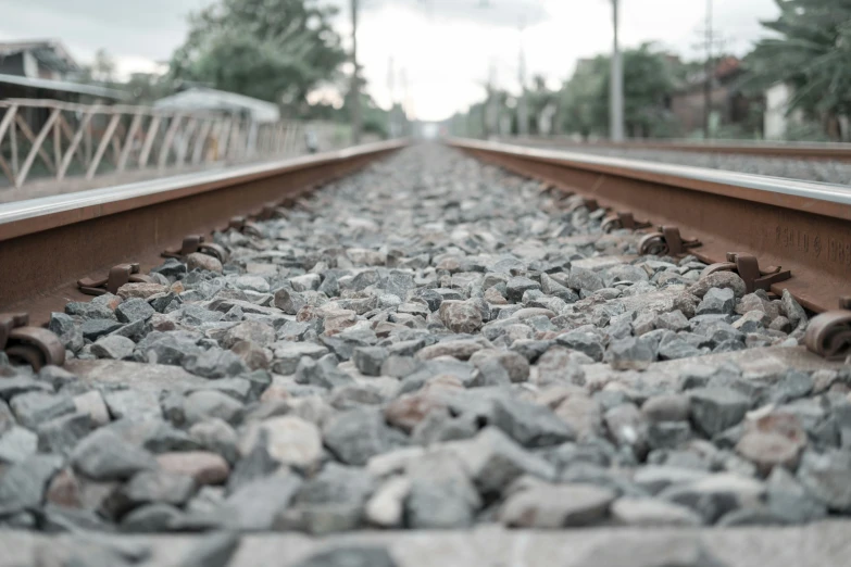 some rocks on a railroad track and a white train in the background