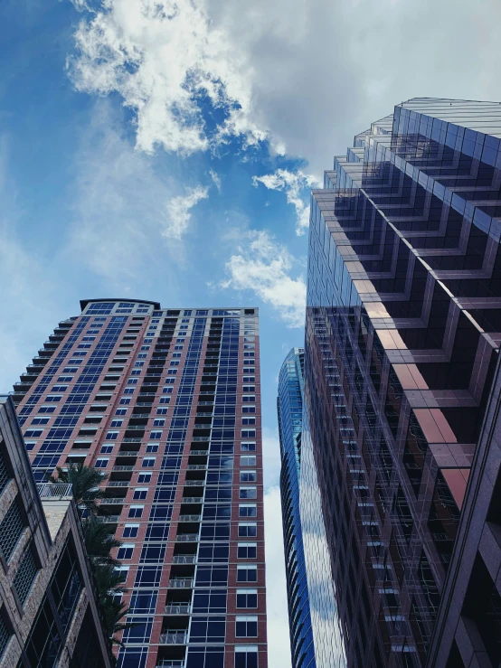 two tall buildings one with windows and the other with balconies