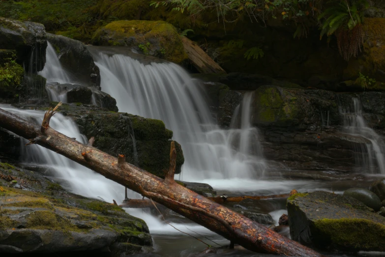 a large water fall that has some moss growing on it