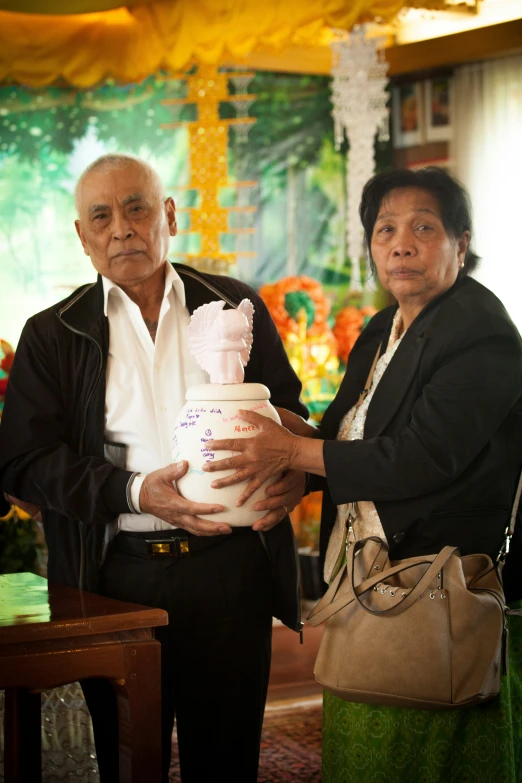 a man and woman standing next to each other holding a bag of stuff