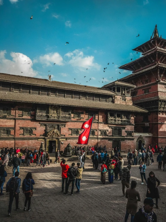 a large group of people standing around in front of a building