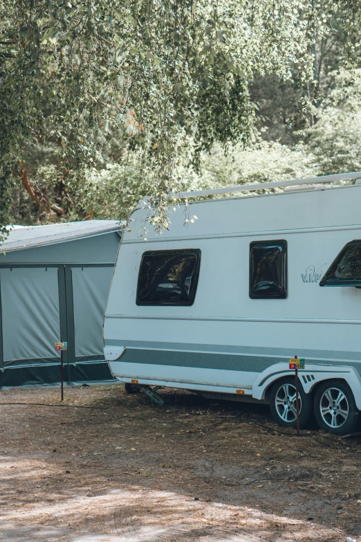 an rv parked next to a blue tent