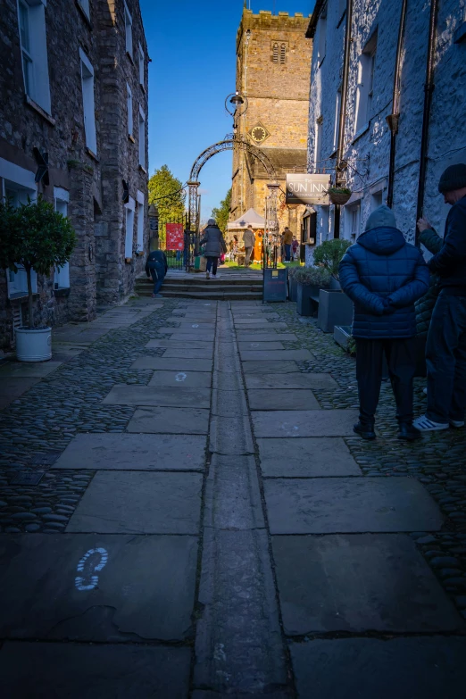 people are standing outside a old stone building