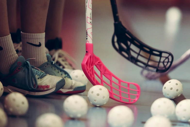 balls, a hockey stick and socks laying on a ground