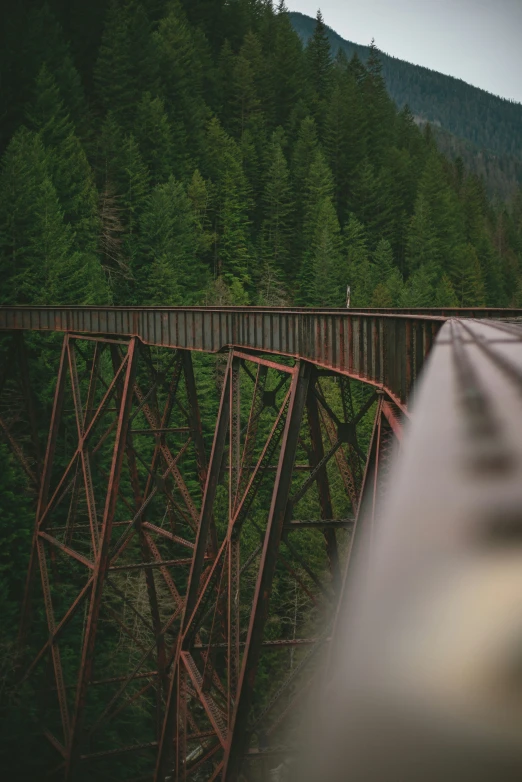 two people stand on the train bridge and watch