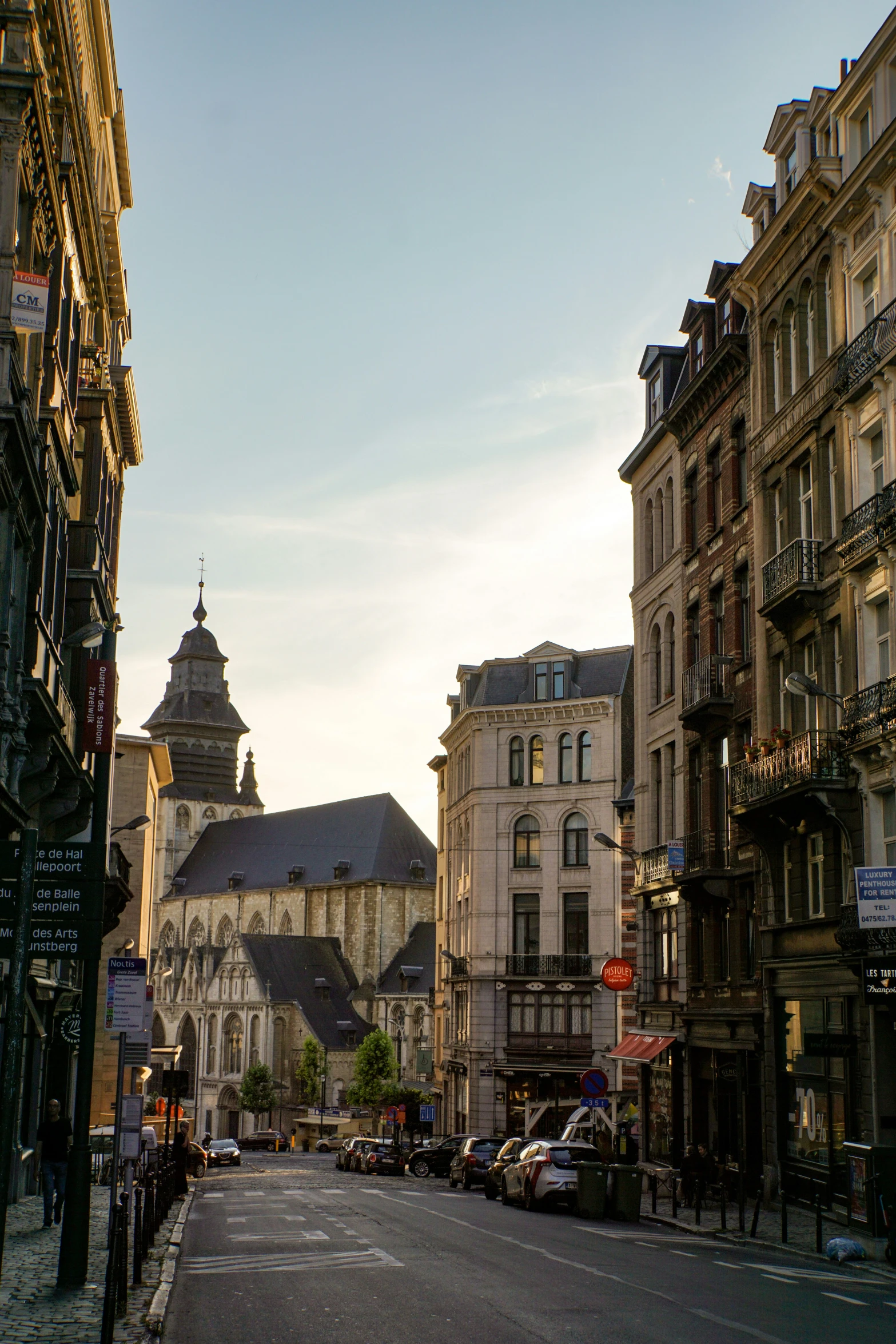 a city street with buildings around it and cars driving on the road