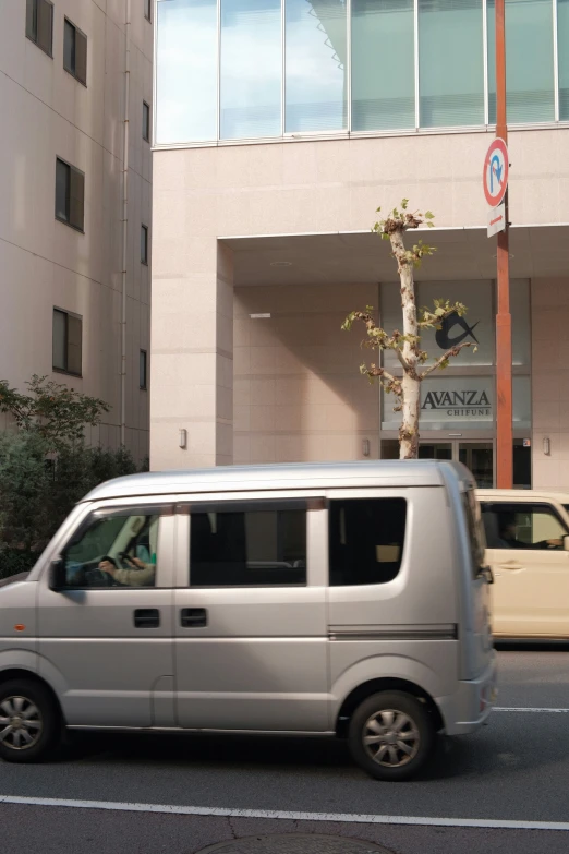 a white van driving down the road next to a building