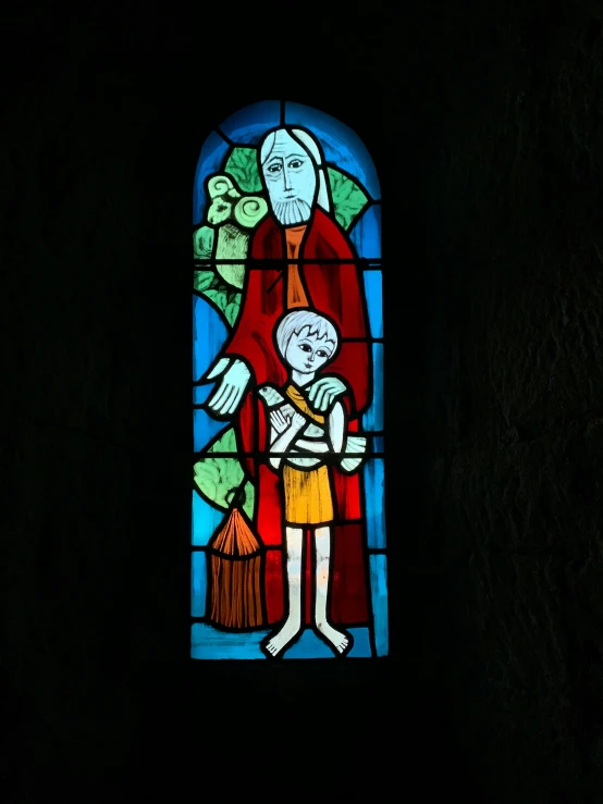 an old stained glass window with a drawing of a man holding a young child