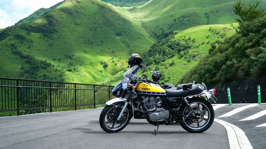 there is a yellow motorcycle that is parked on the street