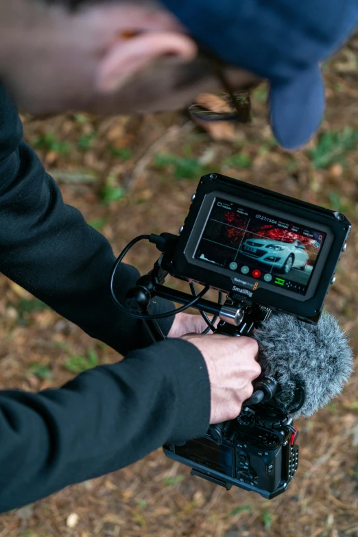 the camera man holds a microphone in front of his camera