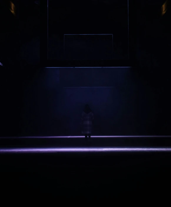 a person standing in the dark looking down