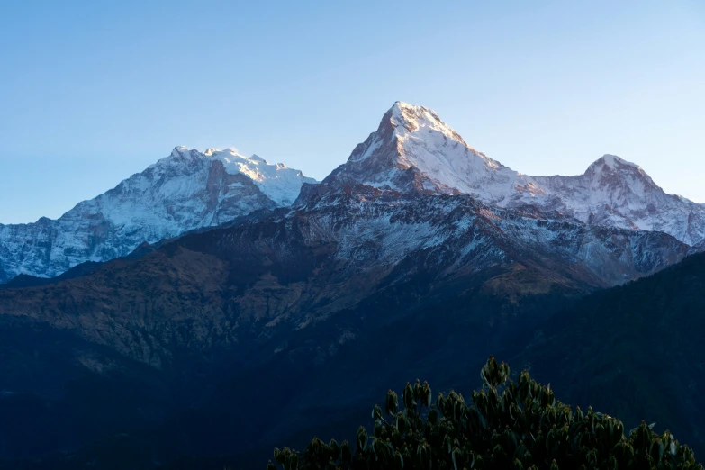 the snowy tops of mountains are bathed in sunlight