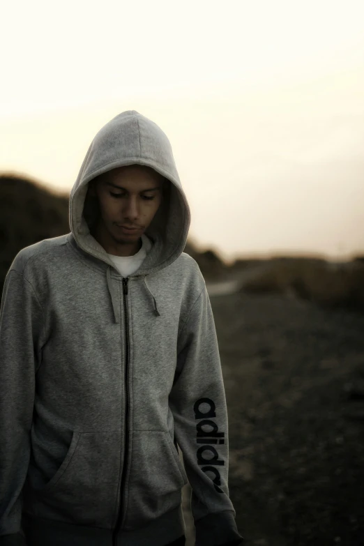 a man with a hoodie on walking down a street