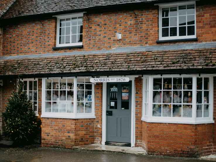 a red brick building with an awning with white windows and signs