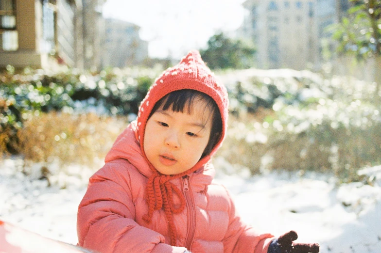 there is a small  in a pink jacket and hat