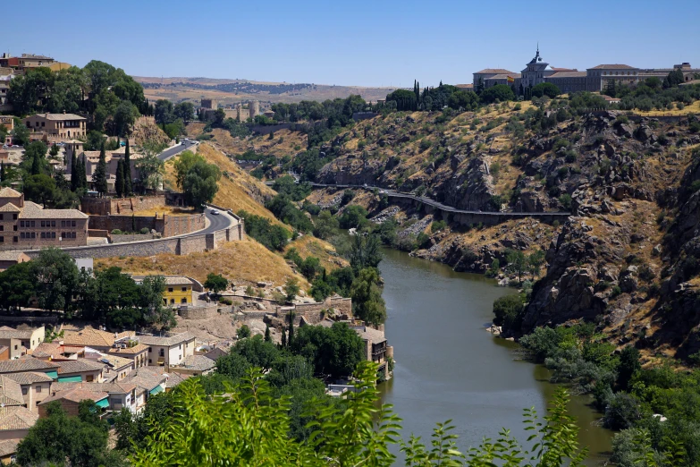 the river that runs alongside a hillside near many buildings