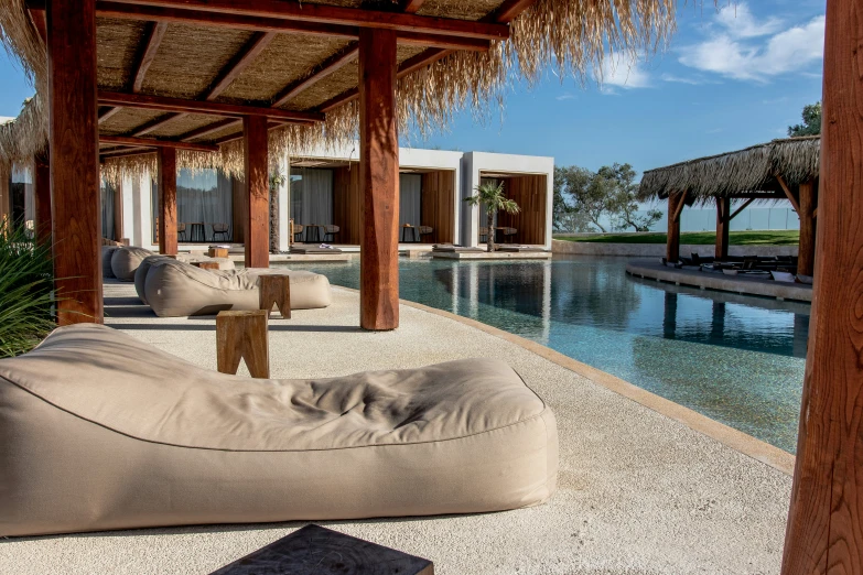 an outdoor lounge with lots of furniture near a pool