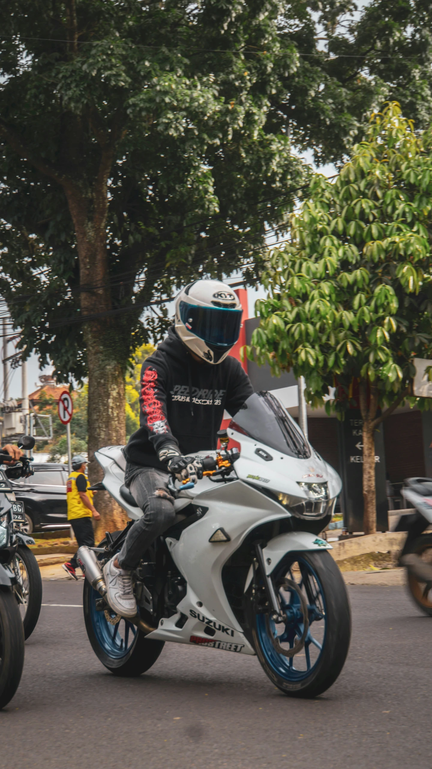 two men on motorcycles driving down the street