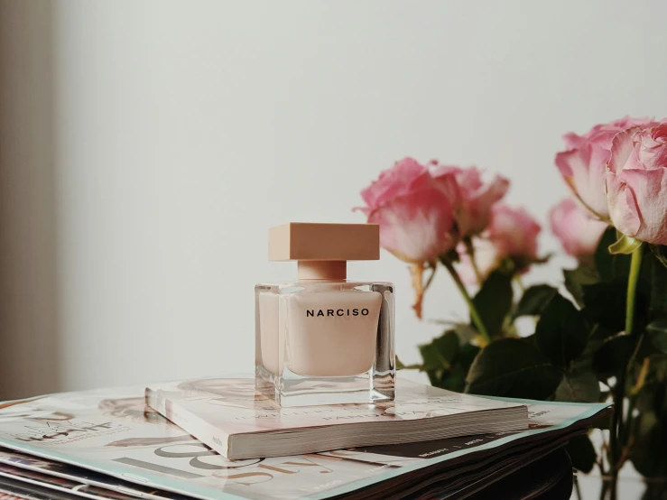 pink roses and a magazine stacked on top of it