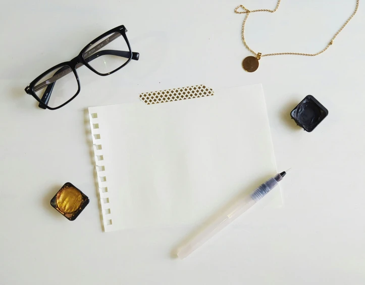 an assortment of items from a pographer including a notebook, camera and eyeglasses