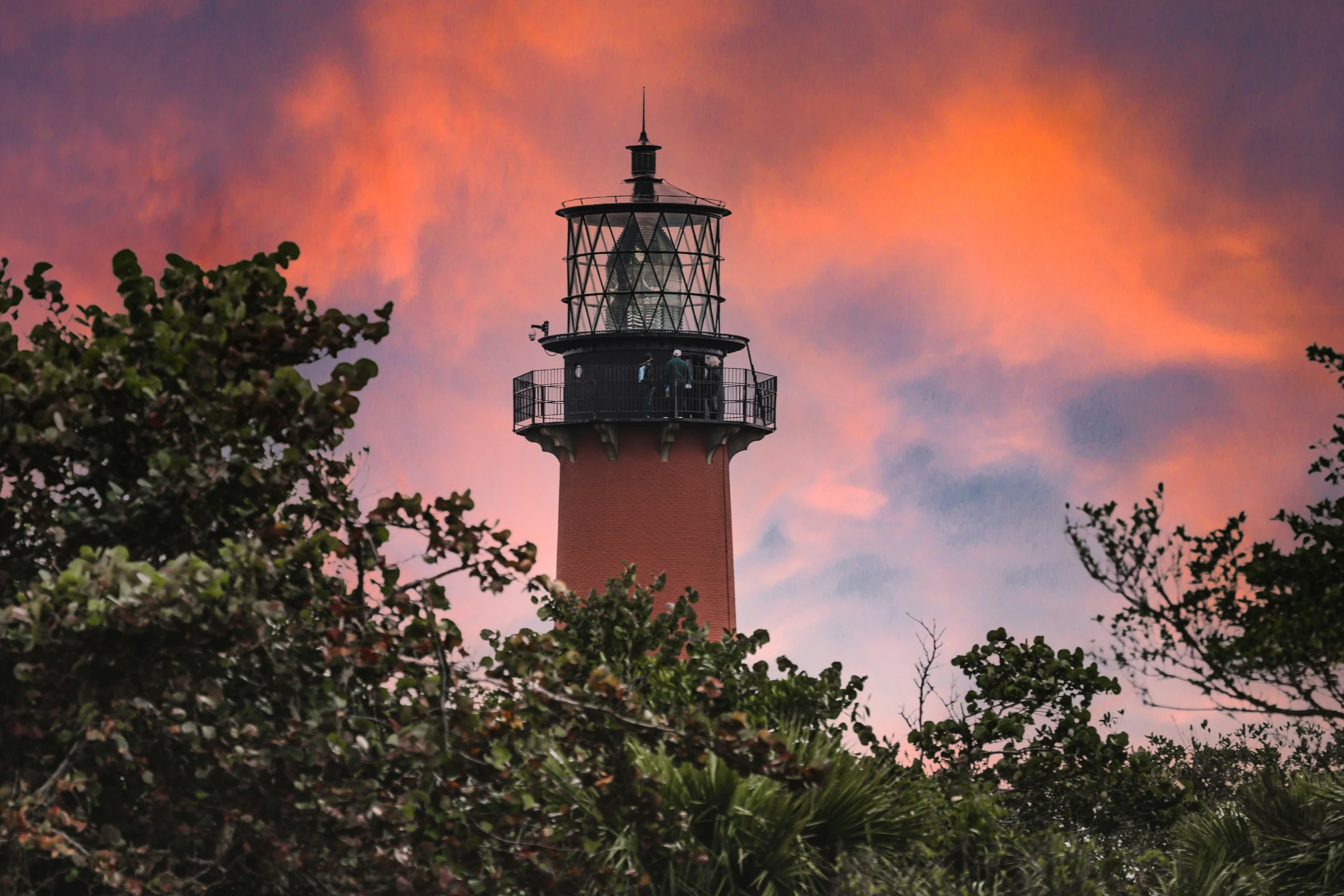 a large light house sitting in the middle of trees