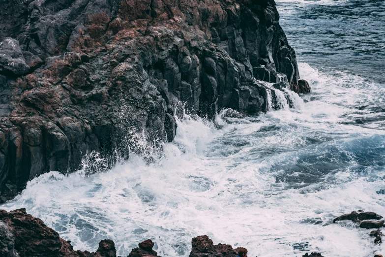 the ocean with large rocks and waves crashing against them