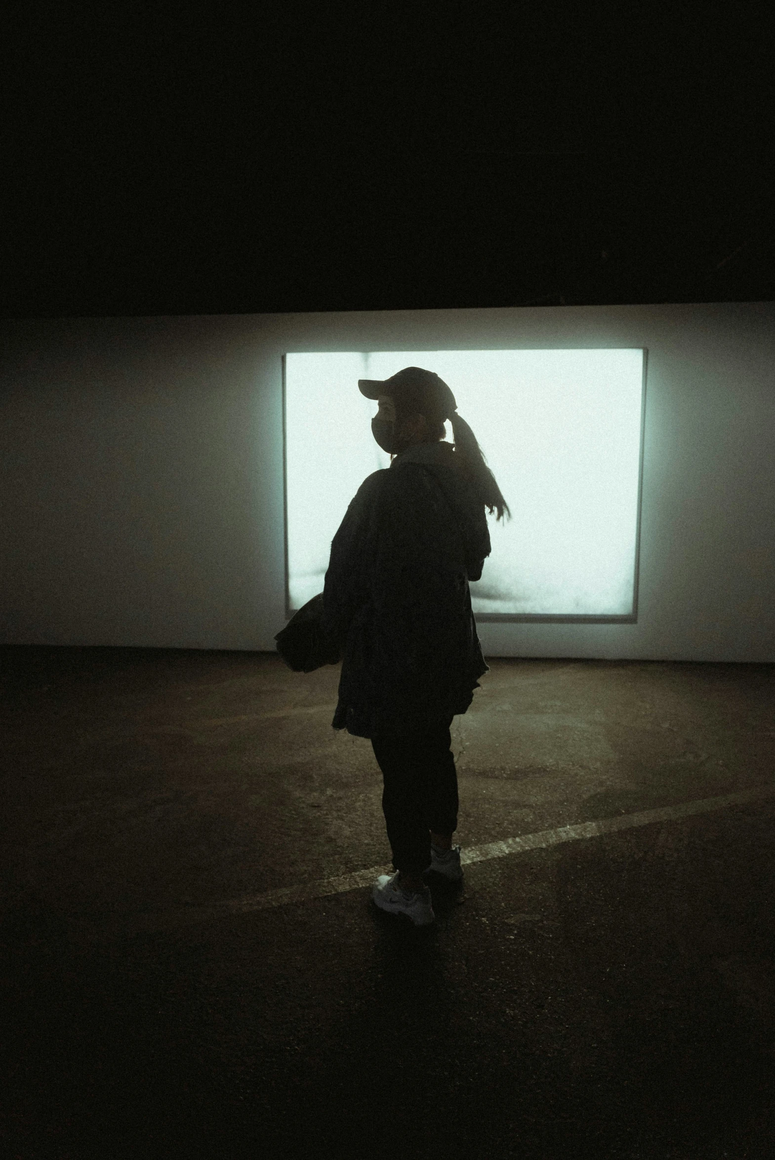 a person in a dark room with their shadow on the wall