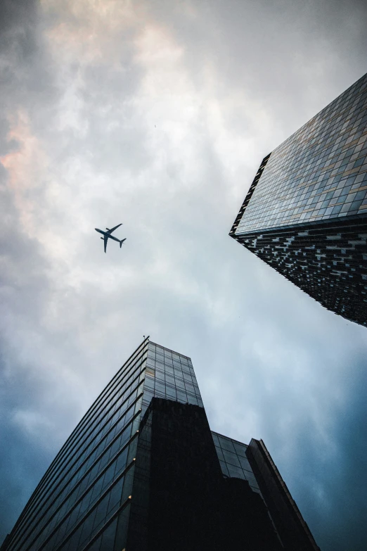 a plane flying above two tall buildings