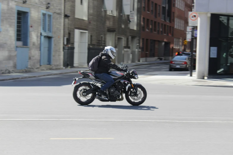 a man riding a motorcycle down a city street