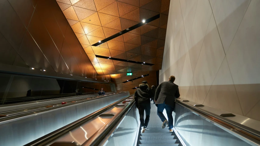 the people are riding on the escalator together