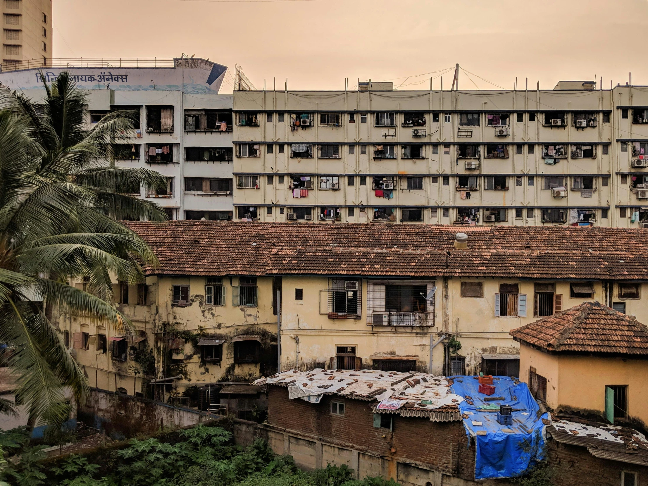 an old building with a blue tarp next to the roof