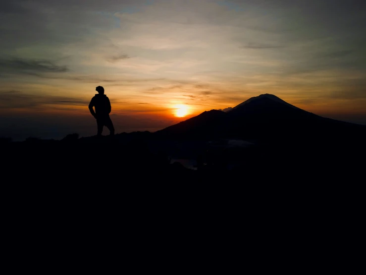 a man stands on a mountaintop in the sun