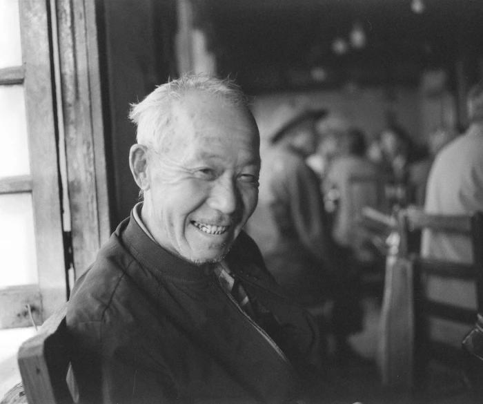 the older man is smiling and sitting at the table