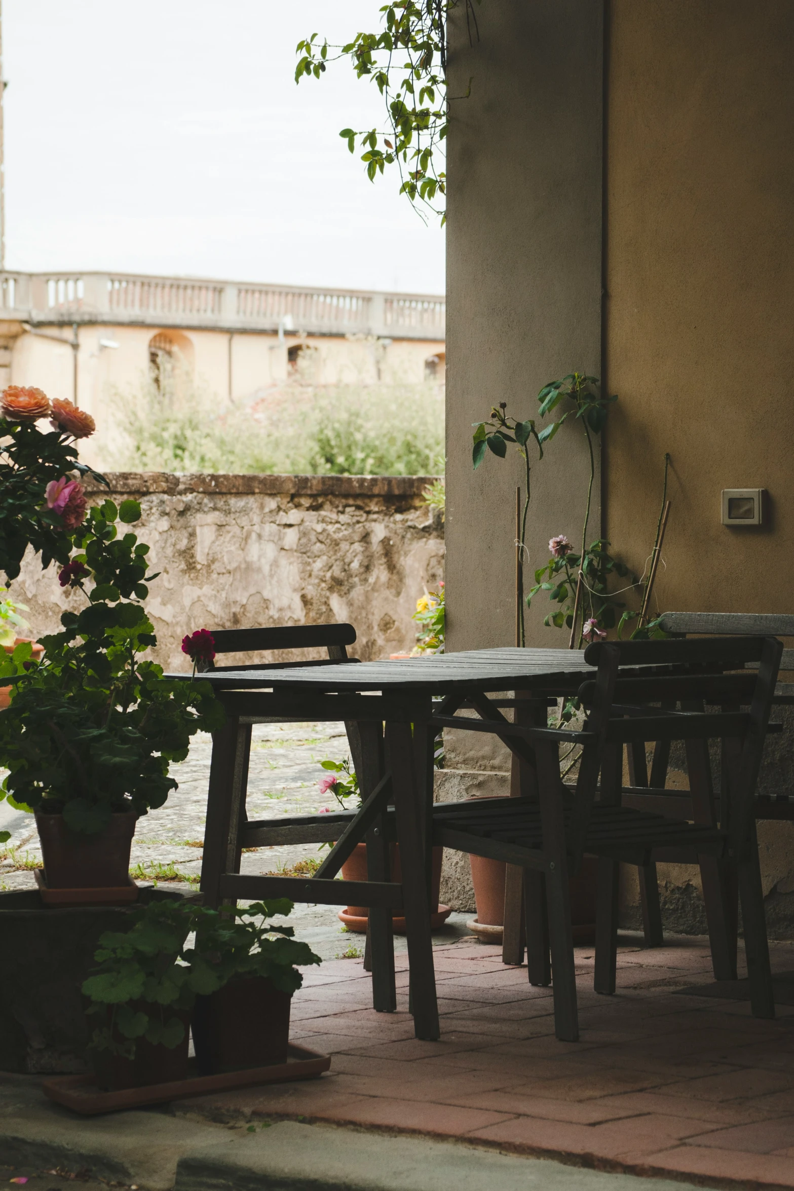 a couple of tables sitting outside in front of a wall