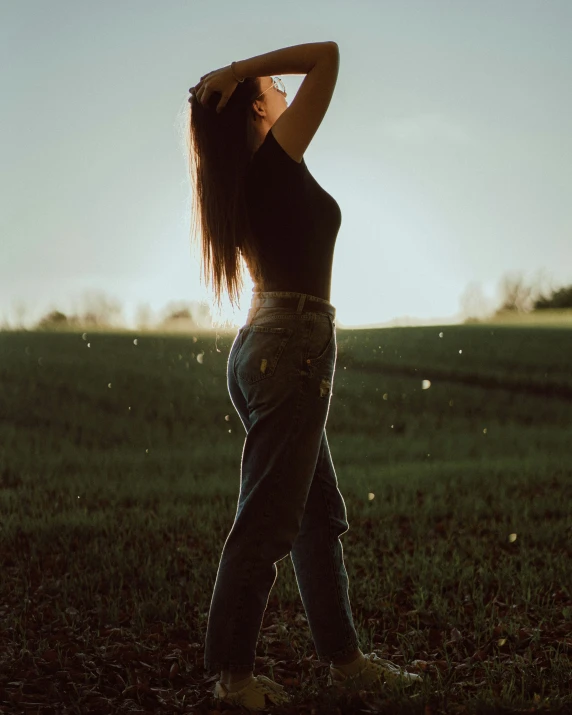a woman is standing in a grassy field