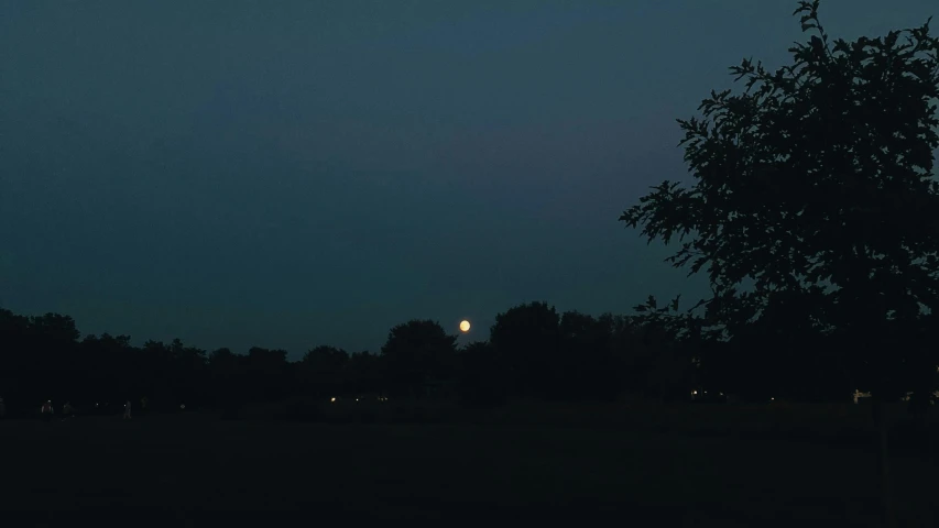 a full moon is seen as the night approaches