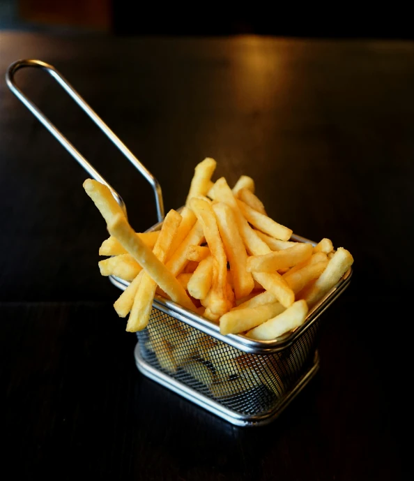 a metal basket that has french fries on it