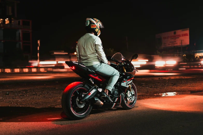 a man sitting on top of a motorcycle in the dark