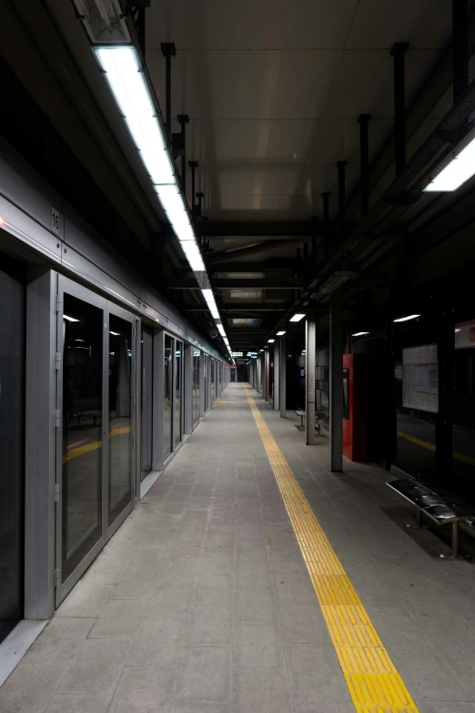 an empty train station with sliding doors and lights