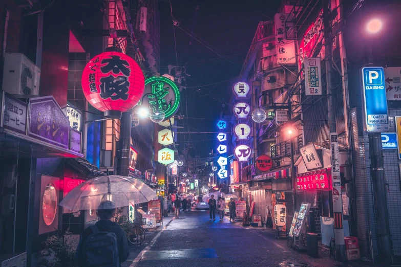 people walk down the city street under many neon signs