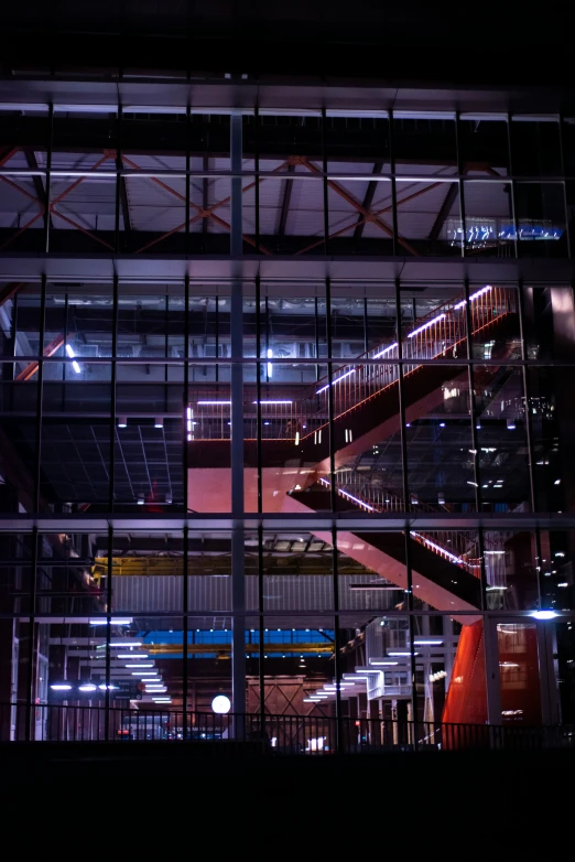 a city at night viewed through windows of a tall building