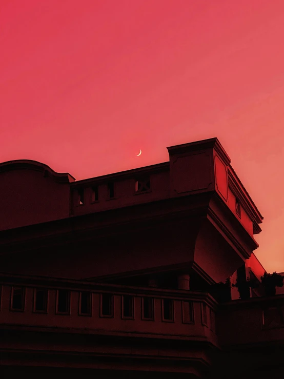 a building with a bright red sky in the background